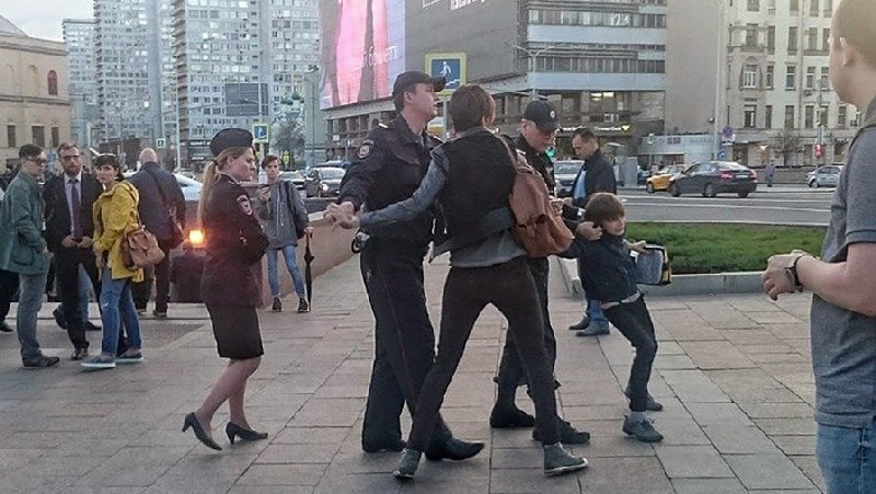 Вот так полицейские вели задержанного мальчика к своей машине.